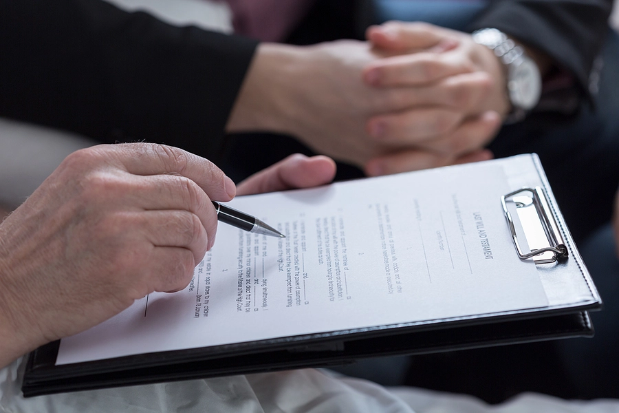 Person filling in a form on a clipboard