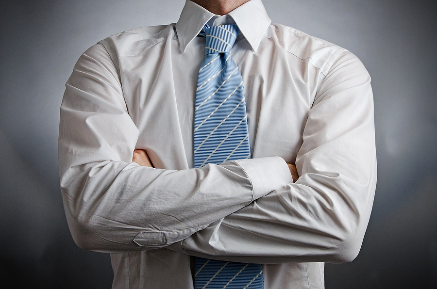 Image of a man wearing a shirt and tie with arms crossed