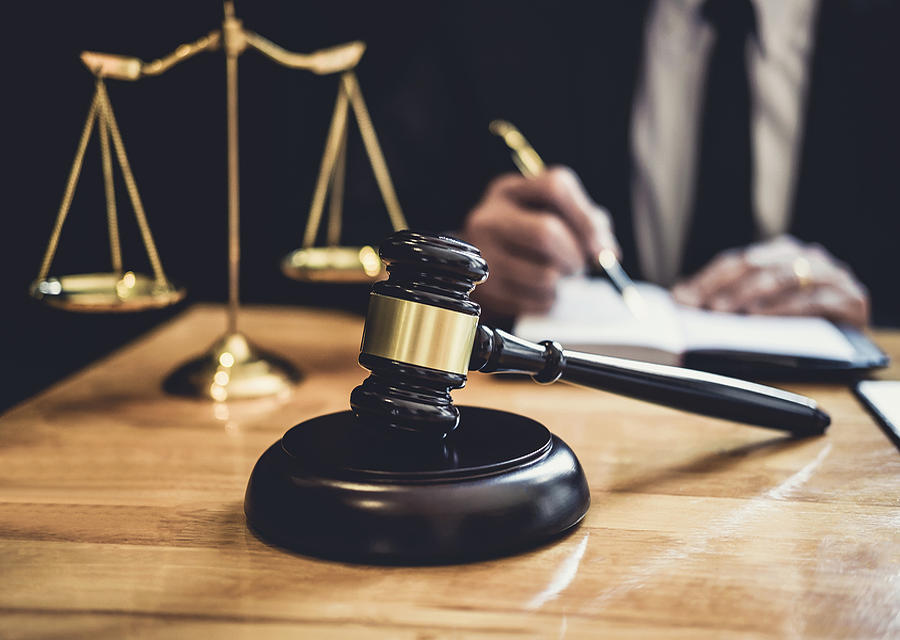 Gavel and scales with laywer signing document